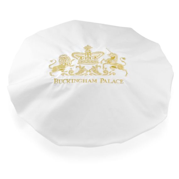 Buckingham Palace logo white shower cap featuring the gold embroidered words Buckingham Palace under a lion and unicorn royal crest. Buckingham Palace logo white shower cap featuring the gold embroidered words Buckingham Palace under a lion and unicorn royal crest.
