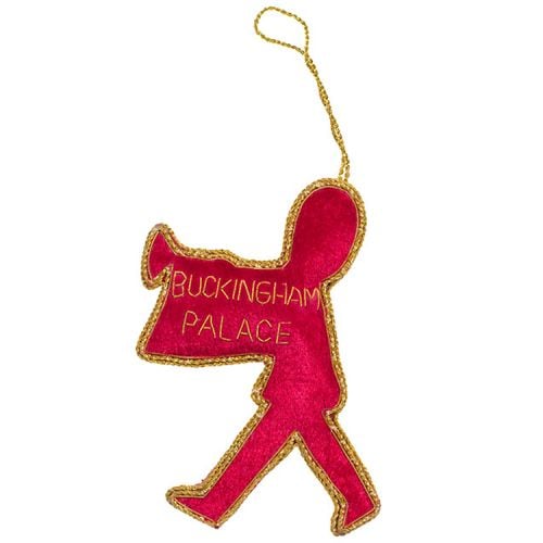 Marching guardsman with trumpet and flag decoration. Red and black material with gold thread surrounding.