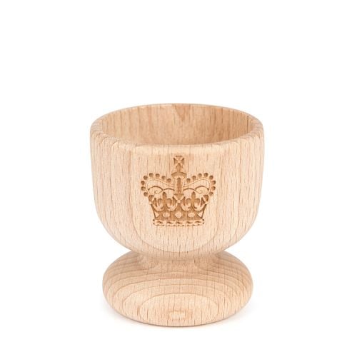 Wooden egg cup with crown motif cut into the front. 