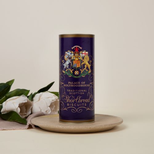 Purple tube of shortbread biscuits featuring the Scottish coat of arms. Next to the biscuit tube are two shortbread biscuits.