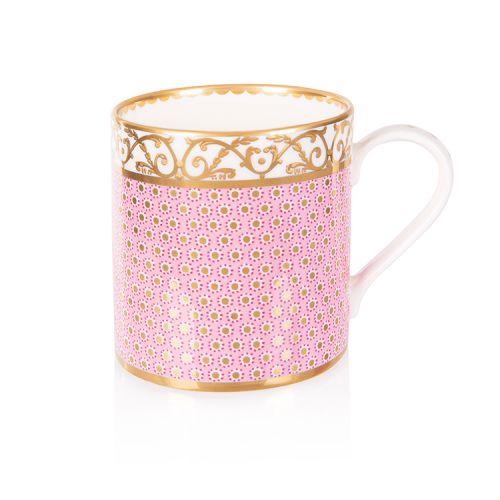 pink patterned coffee mug with a gold design and white handle