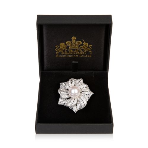 Silver lower brooch made with glass crystal and a costume pearl at the centre.