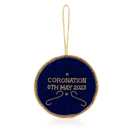 White decoration with gold beading and colourful embroidery. Featuring the Royal coat of arms and date of the Coronation.
