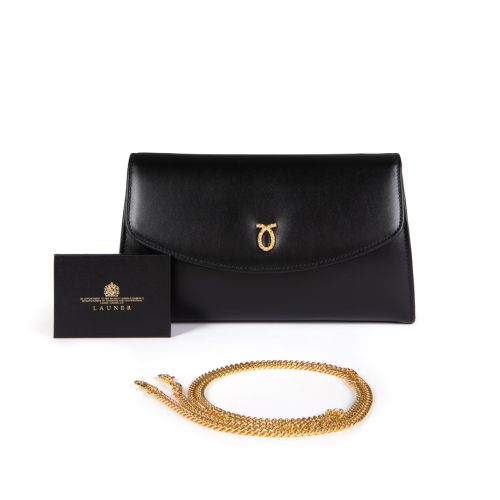 A black leather clutch bag with gold plated logo and fold over