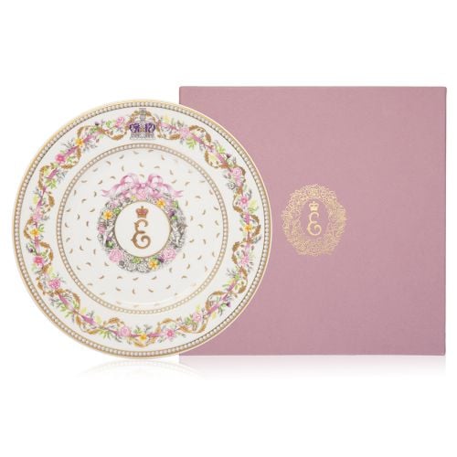 A small dessert plate with Queen Elizabeth II's personal cypher at centre. Surrounded by a floral design and pink ribbon on the edge of the plate with the Imperial State Crown at the top.  