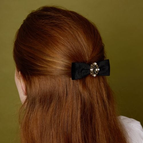 Reverse of  deep navy blue velvet bow hair clip, embellished with coloured gems and faux pearls. 