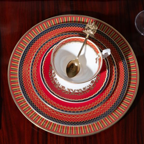 The 10" Livery Dinner Plate, with a striped design that  beautifully combines the deep, rich scarlet tones of ceremonial uniforms with fine gold details, inspired by the intricate decorative braiding and regimental devices on the outer edge. The centre of