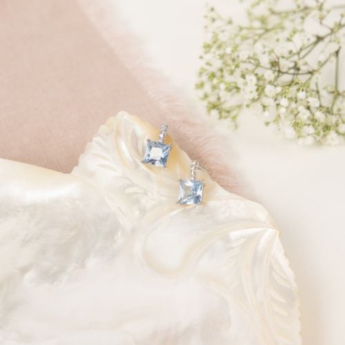 earrings with light blue gems and small silver gem details above.