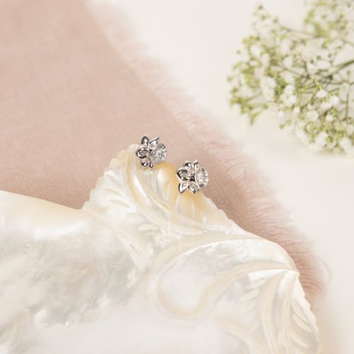 two silver stud earrings in the shape of daffodils