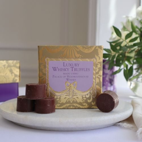 A golden patterned box with with a puple centre, with "Luxury Whisky Truffles, made using Palace of Holyroodhouse Whisky" text at centre in dark purple.